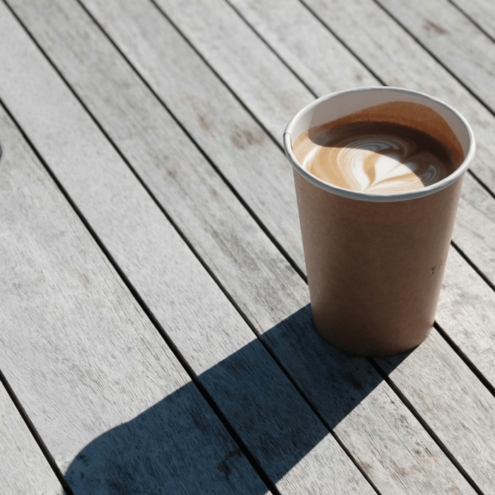 A takeaway coffee cup on a wooden table