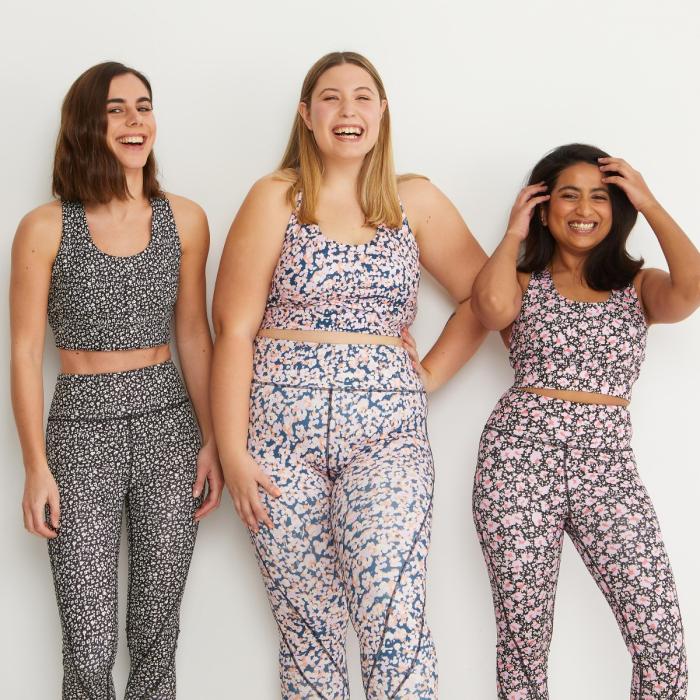 Three smiling models wearing modern printed fitness wear