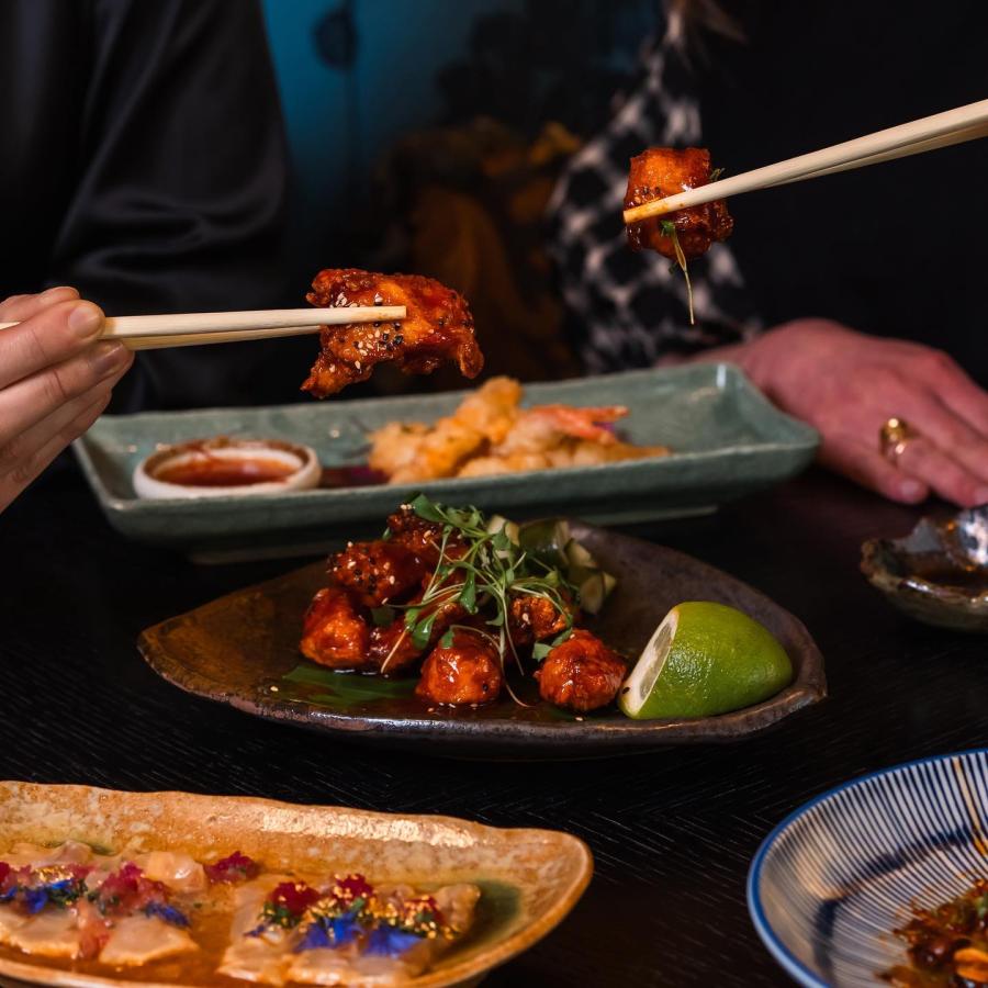 Two people sharing an Asian meal with chopsticks