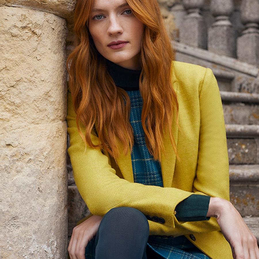 Model in yellow jack and green plaid dress
